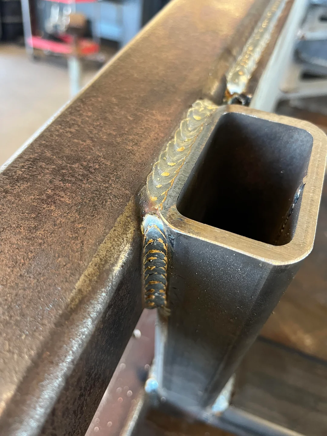Close-up of a MIG weld bead joining square tube to a beam