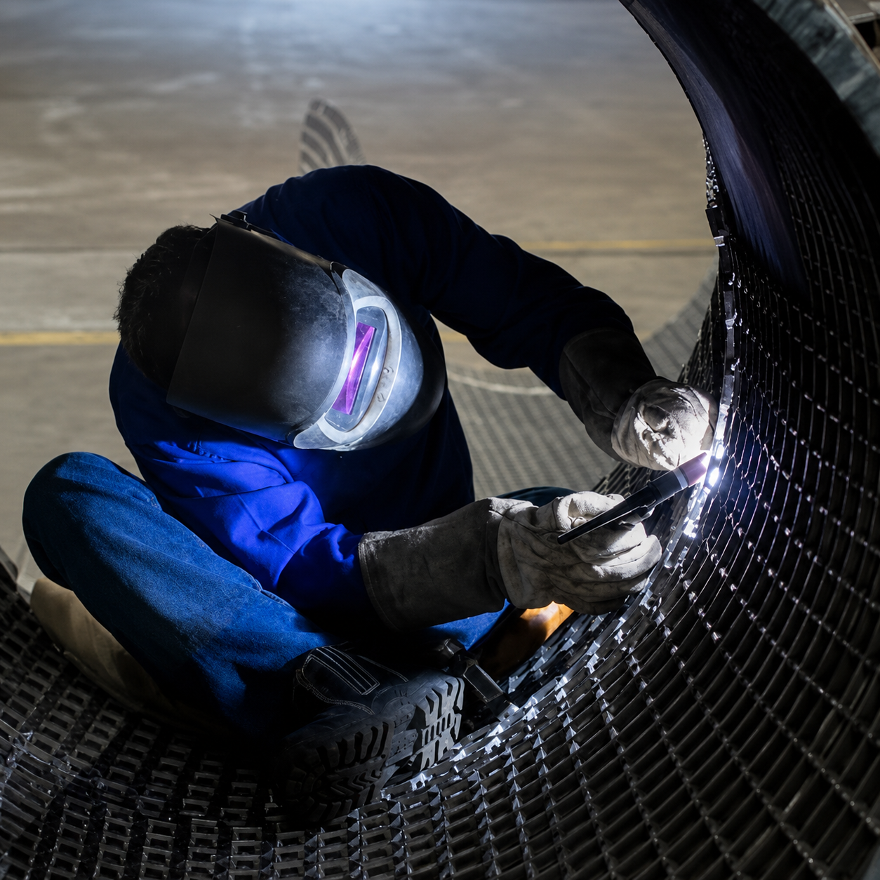 Vitor Santos Andrade welding inside a large steel cylindrical structure